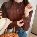 Brown ribbed sweater paired with gold earrings, showcasing cozy fall fashion; features a dark brown color, full sleeves, and a focus on the shoulder and neck area.
