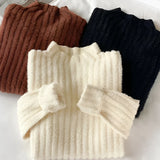 Brown ribbed sweater paired with gold earrings, showcasing a cozy and chic fall outfit. The sweater features long sleeves and a woolen texture, emphasizing its warmth and comfort. The look is accented by stylish gold fashion accessories, perfect for a fashionable autumn ensemble.