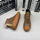Brown suede high-top sneakers with a ribbed sole displayed against a wooden background, showcasing stylish urban footwear design.
