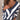 Brown White V-Neck Striped Knit Sweater worn by a woman, showcasing its casual pullover style with blue color accents and large size fitting, featuring long sleeves and a comfortable waist length.