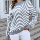 Brown and white zigzag patterned crew neck women's sweater, shown on a model, highlighting the autumn fashion knit design.