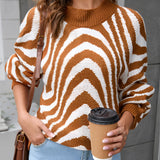 Brown and white zigzag pattern crew neck women's sweater, designed for autumn fashion knit, displayed on a model with jeans.