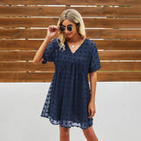 
A woman wearing a marine blue burgundy floral mini dress, accessorized with sunglasses.