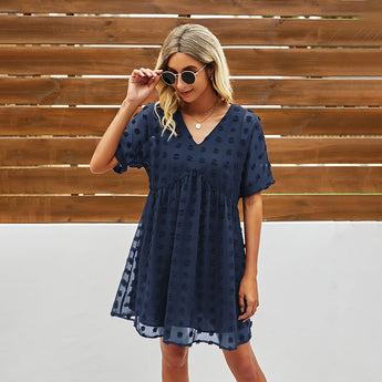 
A woman wearing a marine blue burgundy floral mini dress, accessorized with sunglasses.