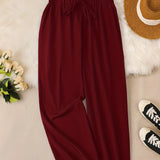 Woman wearing burgundy high-waist wide-leg office pants in size 5XL.
