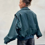 Burgundy oversized leather bomber jacket for women, featuring a trendy fall fashion design with long sleeves and a relaxed fit, highlighting details such as the shoulder, neck, and waist areas.