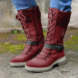 Burgundy women's combat boots with chunky sole and quilted panels, showcased on a human leg.