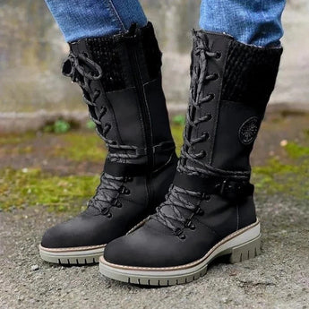 Burgundy women's combat boots with chunky soles and quilted panels, displayed on a grassy surface.