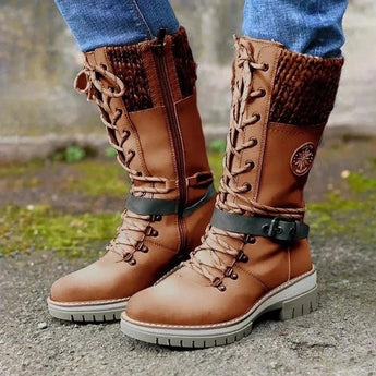 Burgundy women's combat boots with chunky soles and quilted panels, shown outdoors near a tree on grass, highlighting the boots' knee-high length and stylish design.