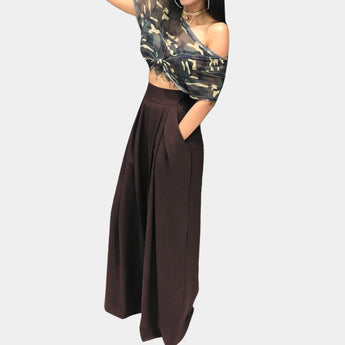 Burgundy women's high-waisted wide-leg palazzo pants in size XL, featuring a brown color. The image includes a person wearing the pants, with visible elements such as hair, shoulder, and arm. The pants are styled as a one-piece garment in a fashionable, relaxed silhouette.