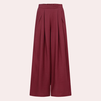 Burgundy women's high-waisted wide-leg palazzo pants displayed against a plain background, showcasing their flowy design and rich color.