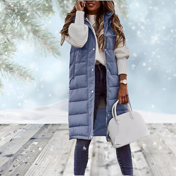 Burgundy women's long puffer coat with detachable hood, featuring a high collar, long sleeves, and waist detail. The model is standing and holding a bag.