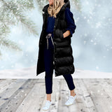 
A black women's long puffer coat with a detachable hood, showcased in a 3XL size. The coat features a sleek design with a full-length style covering down to the knees, long sleeves, and a defined waist. The model is standing, highlighting the coat's fit and structure.