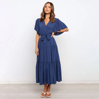 Dark blue midi dress with ruffle skirt and flutter sleeves, featuring a fitted waist and elegant shoulder design, suitable for daytime wear.