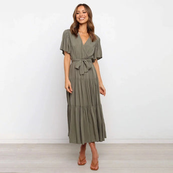 Burnt orange midi dress with ruffle skirt and flutter sleeves, modeled by a smiling person. The dress features a fitted waist and is suitable for daytime wear.