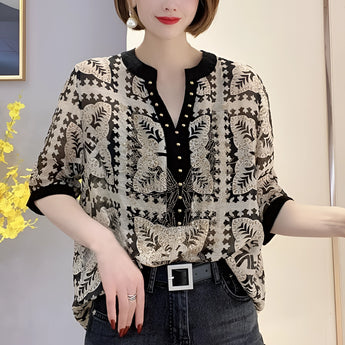 A plus-size bohemian blouse featuring a butterfly print, in black and white colors, with a V-neck and batwing sleeves.