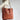 Brown oversized full-grain leather tote bag with minimalist design, featuring durable shoulder straps.
