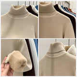 Luxurious cashmere turtleneck sweater in a soft touch fabric, featuring a neutral beige color with subtle grey and white tones. The sweater has long sleeves and a cozy neck design, perfect for winter wear.