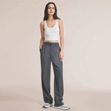 Charcoal gray high waist wide-leg trousers for women, showcasing a fashionable design and paired with a sleeveless shirt.