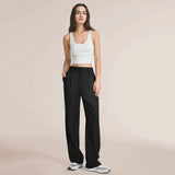 Black high waist wide-leg trousers for women in size 5XL, highlighting the waist and thigh areas, styled with a sleeveless shirt.