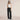 Black high waist wide-leg trousers for women in size 5XL, highlighting the waist and thigh areas, styled with a sleeveless shirt.