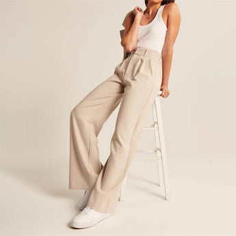 A woman wearing beige wide-leg trousers paired with a matching blazer, highlighting the high-waisted design and elegant fashion style.