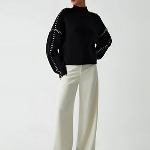Chic black cut-out sweater for women, featuring a stylish designer knitwear design with distinct cut-outs around the shoulders and neck area, showcasing the upper arms and collarbone area. The long sleeves and slim fit accentuate the waist, offering a modern and elegant look.