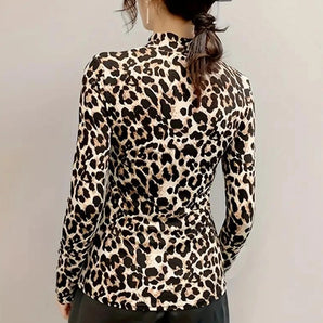 Stylish high neck blouse featuring a bold leopard print design, complete with back button detailing. The blouse showcases long sleeves and a fitted waist, highlighting a chic and fashionable look.