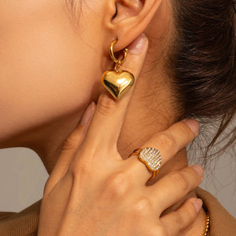 Chic two-tone heart hoop earrings worn on an ear, showcasing romantic Valentine's jewelry.