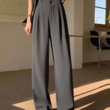 Chic urban women's fashion featuring a model wearing gray wide-leg trousers, a cropped tank top, and a cardigan in size 2XL; posed in front of a window.