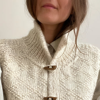 Chunky cable knit vest with wool toggle buttons in grey, featuring a collar and prominent shoulder design.