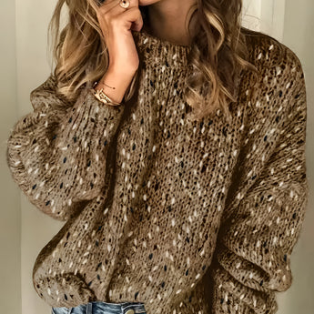 Chunky knit crew neck wool sweater in textured speckled brown worn by a smiling person with coffee-colored hair, styled casually, paired with jeans. The focus is on the upper body, showcasing the sweater's thick knit texture and relaxed fit.