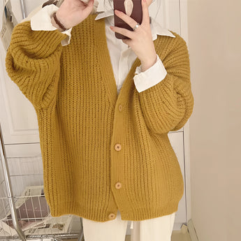 Chunky knit oversized brown cardigan with pockets, shown in a yellow color variant, size 2XL. The cardigan features a cozy wool texture, long sleeves, and covers the shoulders and arms, perfect for layering over a dress shirt.