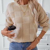 Chunky knit textured beige sweater for women, showcasing autumn fashion. The sweater features long sleeves, a high neck, and a relaxed fit, with intricate knit detailing visible on the textile. The design emphasizes warmth and style, perfect for cooler weather.