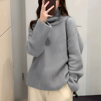 Chunky oversized gray turtleneck wool sweater in XL, featuring warm ribbed knit texture with long sleeves and a high collar, worn by a person standing in front of a mirror.
