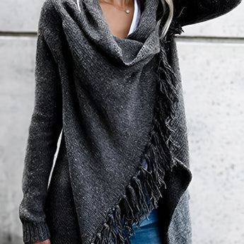Women's chunky turtleneck sweater in black and white, paired with taupe ankle boots, showcasing a winter knitwear style. The sweater features long sleeves and a relaxed fit, photographed against a grey background.