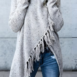 
A woman wearing a chunky turtleneck sweater in a winter fashion setting, paired with taupe ankle boots. She is seated, showcasing the outfit's style and detail against a simple background. The sweater's texture and design are highlighted, emphasizing its suitability for cold weather.