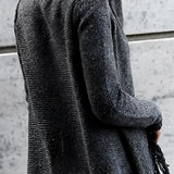 Chunky turtleneck sweater in shades of white and grey with long sleeves, paired with taupe ankle boots, displayed as women's winter knitwear.