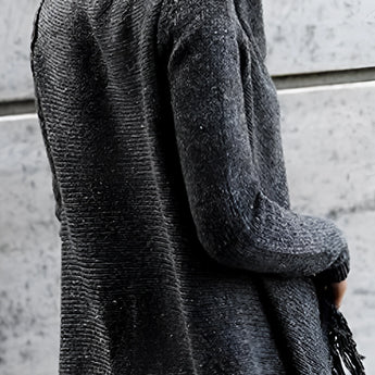 Chunky turtleneck sweater in shades of white and grey with long sleeves, paired with taupe ankle boots, displayed as women's winter knitwear.