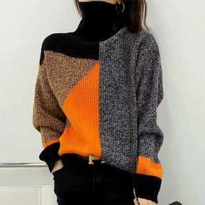 Woman wearing a color block geometric knit turtleneck sweater in orange, featuring long sleeves and a stylish fall fashion design.
