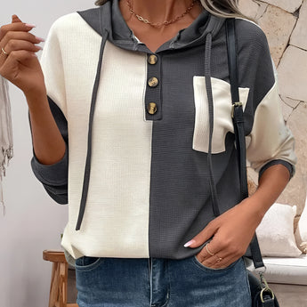 Women's color-block button-up hoodie in casual autumn fashion, featuring white and black sections, with a focus on the shoulder, arm, and neck areas.