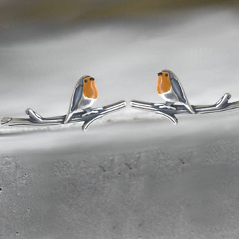 Colorful bird-shaped earrings featuring intricate designs of European robins perched on twigs, crafted in metal.