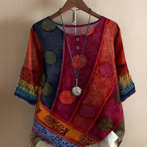 Colorful bohemian patchwork blouse featuring an ethnic print design, displayed on a clothes hanger. The blouse is plus size, in a vibrant red color, and has a 4XL size. The top includes a collar and sleeves, showcasing a stylish and eclectic fashion design.