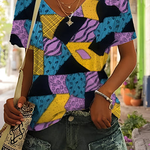Colorful geometric women's summer top in a bold pattern blouse, featuring a mix of purple, green, and black shapes, shown in size 2XL. The design includes a fashionable neckline and is ideal for summer wear.