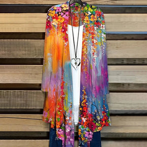 A vibrant orange 3XL kimono cardigan featuring a colorful floral pattern, displayed on a clothes hanger. The bohemian summer cover-up highlights an array of bright hues including magenta and electric blue, with a flowing sleeve design that adds to its fashionable charm.