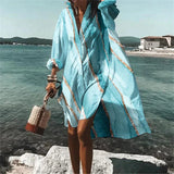 Colorful retro print kaftan in a vibrant psychedelic design, worn by a person with shoulder-length sleeves, standing against a backdrop of water and azure sky, evoking a beachy and stylish vibe. The kaftan is in the Azzurro color and size 5XL, ideal as a beach cover-up.