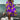 Colorful retro print kaftan in vibrant psychedelic patterns, primarily in purple and violet hues, designed as a beach cover-up. The kaftan is modeled by a person standing against a backdrop of azure sky and beach scenery, emphasizing a relaxed and stylish look ideal for travel and beachwear.