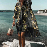 Colorful retro print kaftan in vibrant psychedelic patterns, worn by a person standing outdoors, suitable as a beach cover-up. The kaftan features long sleeves and a flowing design, ideal for summer fashion and travel.