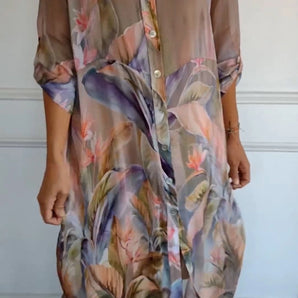 Colorful sheer floral tunic dress in a tropical print, featuring lightweight fabric suitable for summer. The dress is designed with a day dress style, including a collar, short sleeves, and a defined waist. Shown in size S.