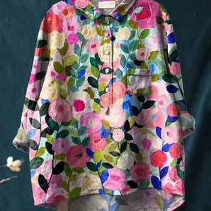 Colorful women's floral button-up blouse with a collar and short sleeves, featuring a vibrant pink and multi-pattern design.